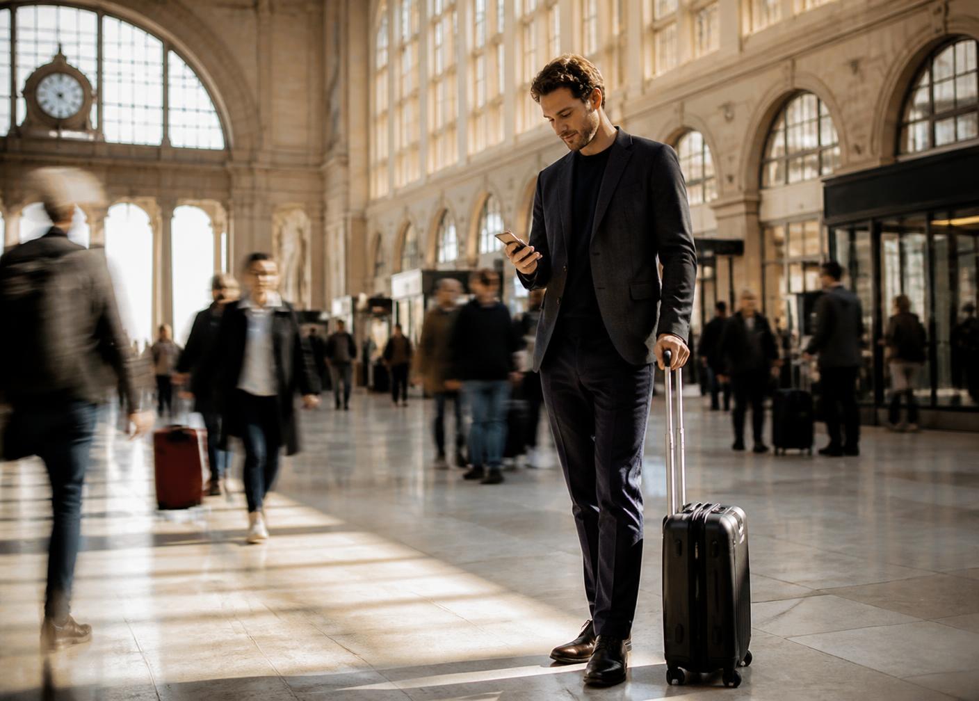 Zakenreiziger die mobiele data checkt in een Europees treinstation
